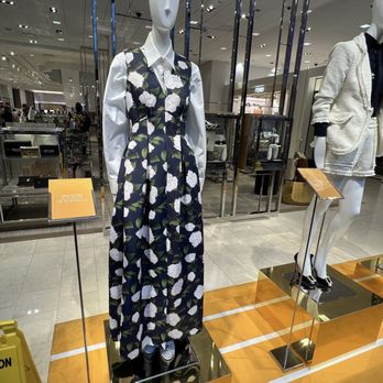 Neiman Marcus - Mannequin displays a floral jumpsuit with a white shirt underneath in a shopping mall, with store signage and other mannequins visible in the background. - Shoe Stores Near Me - Chicago, Illinois