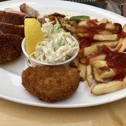 Some lobster-stuffed chicken, a crabcake, french fries, vegetables, coleslaw
