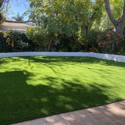 Artificial turf and white stucco retaining wall