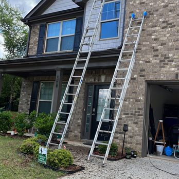 Serrano Construction - a man on a ladder working on a house - Painters Near Me