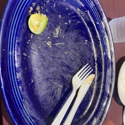 a blue plate with a half eaten lime