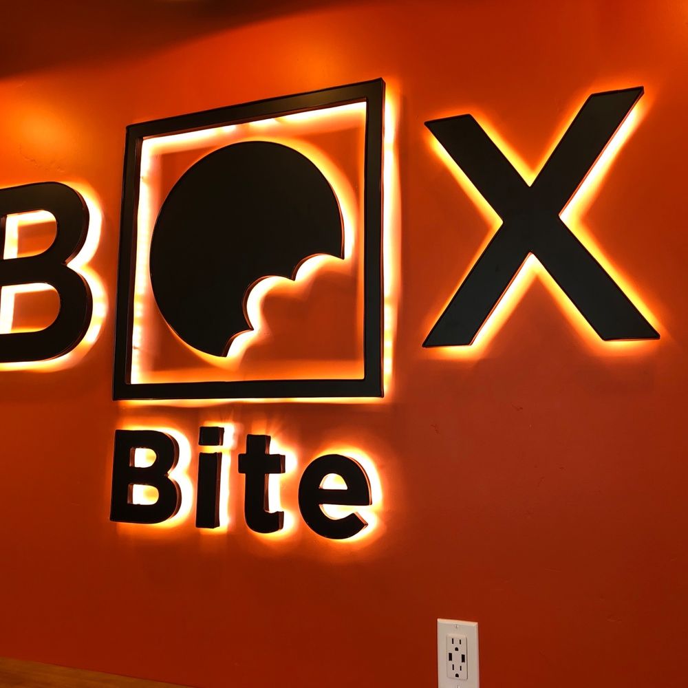 Box Bite - a neon sign on a red wall - Pizza Near Me - American Fork, Utah Box Bite - a neon sign on a red wall - Pizza Near Me - American Fork, Utah