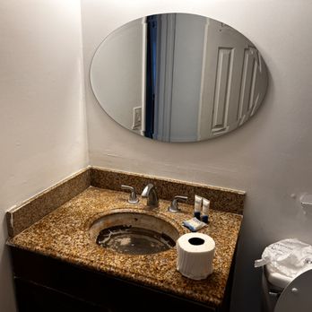 NCC Construction - a bathroom sink with a round mirror above it - General Contractors Near Me NCC Construction - a bathroom sink with a round mirror above it - General Contractors Near Me