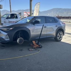 Felipe's Tires - The car jacked up with the tire being repaired.