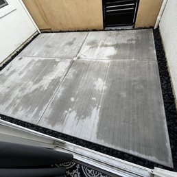a concrete patio with black pebbles
