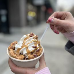 a hand holding a cup of ice cream