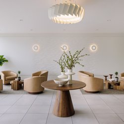 Vine Dental - Full lobby at Vine Dental with swivel chairs, a centre table and floor-to-ceiling windows at our Kelowna dentist office.