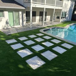 GreenView Direct - Artificial turf installation with concrete stepping stone pavers and backyard remodel around a swimming pool in Pacific Palisades