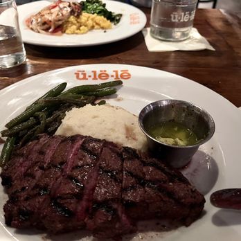 Ulele - Flank Steak  Thin sliced garlic, salt and olive oil marinated beef, avocado chimichurri, roasted garlic mashed potatoes, seasonal vegetable - New American Near Me - Tampa, Florida
