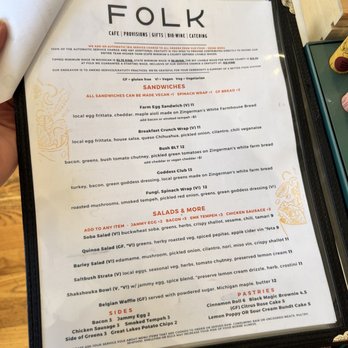Folk - a person holding a menu in their hand - Cafes Near Me - Detroit, Michigan