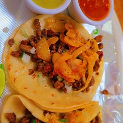 Two street tacos with tomatillo salsa and red spicy sauce....