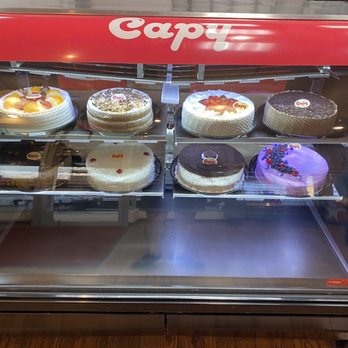 Capy - a display case filled with cakes - Desserts Near Me - Corona, New York
