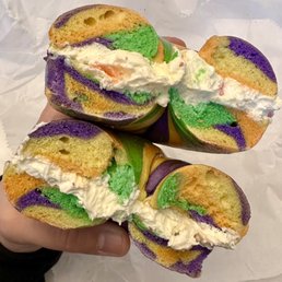 a hand holding a half eaten bagel
