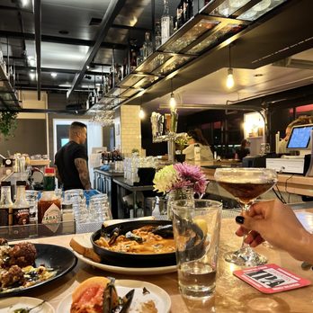 Solana Beach Kitchen - a table with plates of food and a glass of wine - New American Near Me - Solana Beach, California