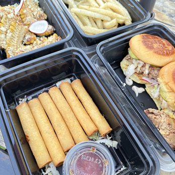 Pogi - four trays of food on a table - Food Trucks Near Me - Austin, Texas Pogi - four trays of food on a table - Food Trucks Near Me - Austin, Texas