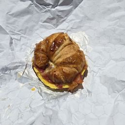 Breakfast sandwich w egg bacon cheese on a croissant.