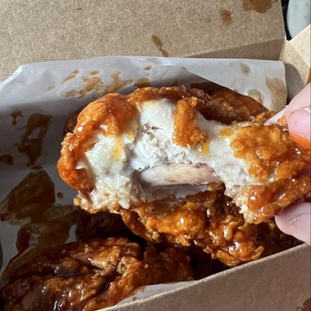 Chicko Chicken - Chicken wing drumstick in sweet and spicy sauce. Bitten to show interior doneness. - Korean Near Me - Whittier, California