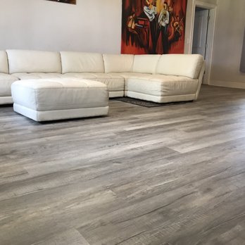 EnVy Floors - a living room with a white sectional couch - Flooring Near Me - Palm Harbor, Florida