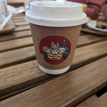 Accio Cup - a woman sitting at a table with a cup of coffee - Cafes Near Me - Montreal, Quebec