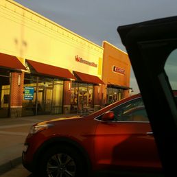 a red car parked in front of a store a red car parked in front of a store