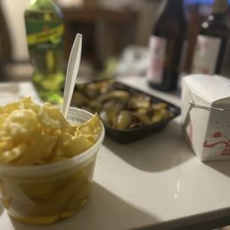 a bowl of chips and a container of pickles a bowl of chips and a container of pickles