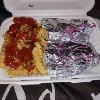 Miss Erica's Kitchen - Chicken cheese steak and crinkle cut fries - A foam takeout box contains waffle fries with ketchup and two foil-wrapped food items, likely sandwiches or burritos. - Food Delivery Services Near Me - Baltimore, Maryland
