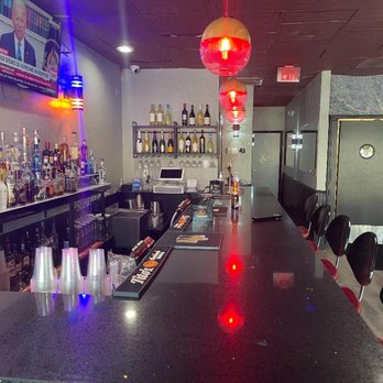 Zoba Lounge - a bar with a lot of bottles on the counter - Hookah Bars Near Me - Pompano Beach, Florida