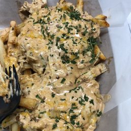 a plate of french fries and a fork a plate of french fries and a fork
