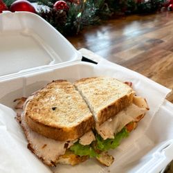 Alexander's Market & Deli - THE TURKEY CLUB:  Served on Sourdough, Oven Roasted Turkey, Bacon, Cheddar Cheese, Lettuce and Tomato with Roasted Garlic Aioli.