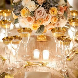 Northern Greenhouses - Cream and antique champagne garden roses, apricot ranunculus & gray succulents in a romantic gold footed vase.