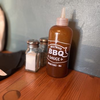 Sweetwood BBQ - a bottle of bbq sauce next to a knife - Barbeque Near Me - Wenatchee, Washington Sweetwood BBQ - a bottle of bbq sauce next to a knife - Barbeque Near Me - Wenatchee, Washington