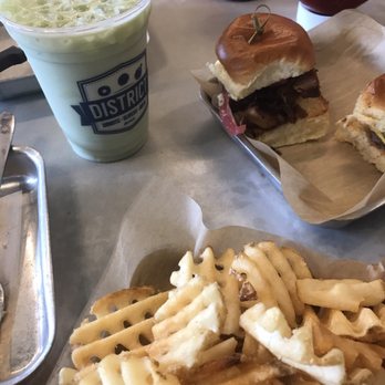 District Donuts Sliders Brew - Waffle fries...pork belly slider...cheeseburger, and chicken slider was hiding but they were all very good! Green tea iced latte - Donuts Near Me - Jefferson, Louisiana