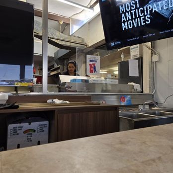 Grab and Go - The Cafe counter with the kitchen in the background with the wife, cook, and co-owner, preparing the food for some customers. - Convenience Stores Near Me - Roanoke, Virginia