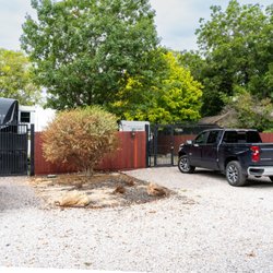 Skyline RV Park - A closer look at Skyline's gated RV spaces, with gravel parking areas, landscaped borders, and trees overhead.