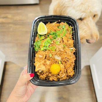Tee Sud Thai Rustic and Bar - a person holding a tray of food with a dog in the background - Bars Near Me - Snohomish, Washington Tee Sud Thai Rustic and Bar - a person holding a tray of food with a dog in the background - Bars Near Me - Snohomish, Washington