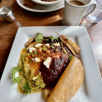 Cafe Pasqual's - HUEVOS MOTULEÑOS ~ Two Eggs / Sautéed Banana / Feta / Green Peas / Organic Corn Tortilla / Black Beans Choice: Red / Green / Xmas / Tomatilo - Vegetarian Near Me - Santa Fe, New Mexico