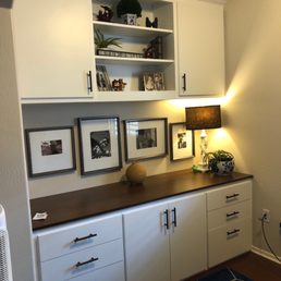 a kitchen with white cabinets and a blue area rug