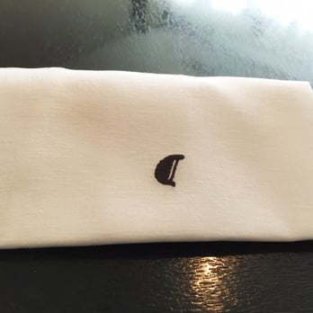 Alinea - The eponymous Alinea symbol-- a typographical character-- featured on the table napkin. - New American Near Me - Chicago, Illinois