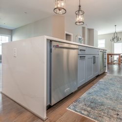 Reico Kitchen & Bath - Merillat Masterpiece Montresano in Moonshine and Lagoon finish with Silestone Calacatta Gold countertops and KitchenAid appliances.