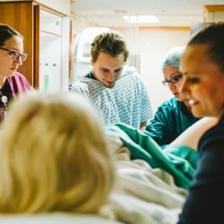 Utah Doula Services - Supporting a mom through the pushing phase of labor while Dad catches baby.