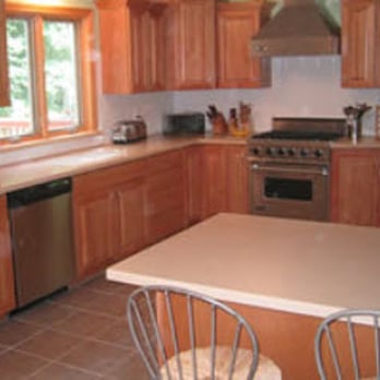 Valley Kitchens - a kitchen with wooden cabinets and a white countertop - General Contractors Near Me - Southampton, Massachusetts