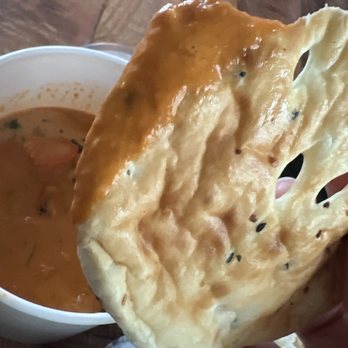 More Curry! - Garlic naan dipped in butter chicken. YUM! - Indian Near Me - Corona, California