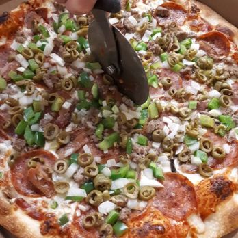 Bedrock Cafe - a person cutting a pepperoni pizza - Pizza Near Me - Orillia, Ontario Bedrock Cafe - a person cutting a pepperoni pizza - Pizza Near Me - Orillia, Ontario