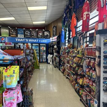 Eddies Market - Interior of a convenience store with sports jerseys hanging on the right, snack shelves, and beverage refrigerators at the back. - Grocery Near Me - Albuquerque, New Mexico