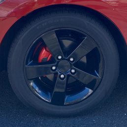 Close up of amazing black gloss rims and bright red calipers.