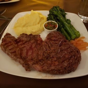 Stone Hearth Grille - 14 oz ribeye steak with a side of chimichurri sauce plus mashed potatoes and veggies. - American Near Me - Tropic, Utah Stone Hearth Grille - 14 oz ribeye steak with a side of chimichurri sauce plus mashed potatoes and veggies. - American Near Me - Tropic, Utah