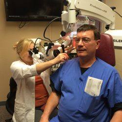 Better Hearing Center - Dr. Pike inserting invisible Hearing Aids