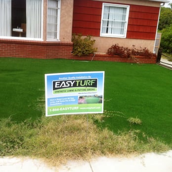 Biltright Turf - Weeds growing in yard and depression behind sign. - Landscaping Near Me
