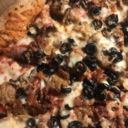 a pizza with meat, olives, and cheese