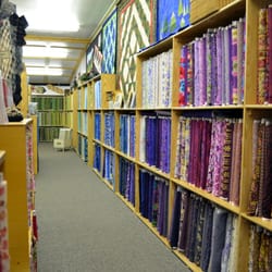 The Quilt Patch - Reds, pinks, oranges, purples, blues, and greens grace this aisle on the lower level of the shop.